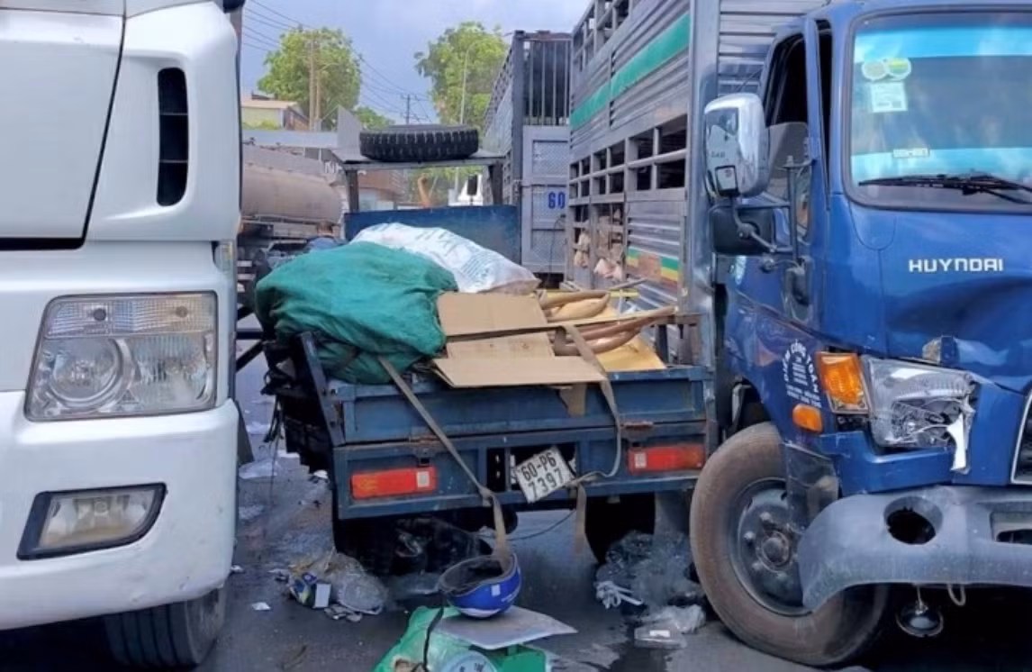 Xe ba gác bị kẹp giữa hai xe tải, bị hư hỏng, nhiều đồ đạc rơi ra ngoài.