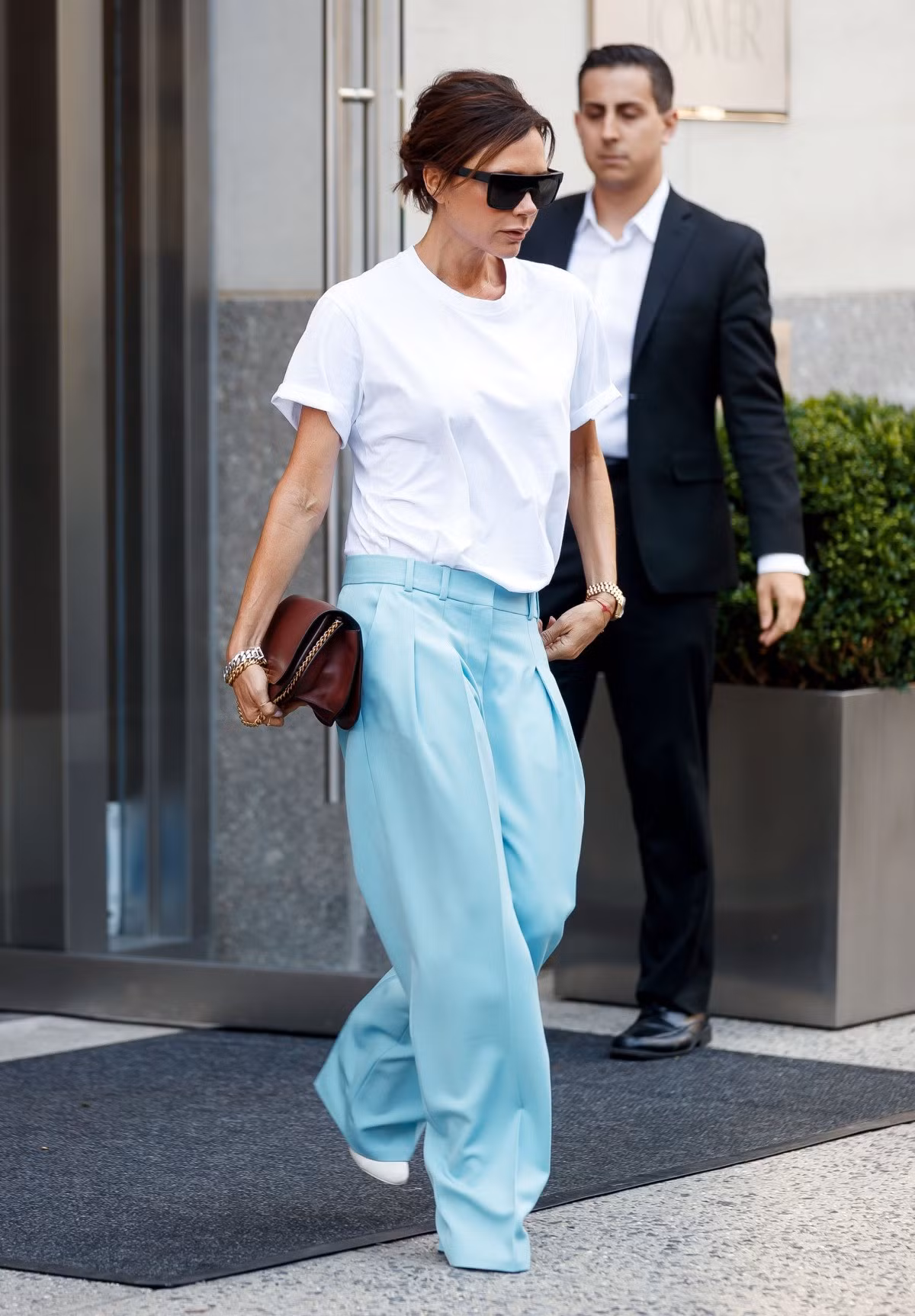 Trong số các ngôi sao thời trang, Victoria Beckham nằm trong nhóm có nhiều trang phục công sở ấn tượng nhất. Bạn có thể học nhà thiết kế cách phối áo phông trắng và quần vải ống suông, giày gót nhọn màu nổi. Ảnh: SplashNews