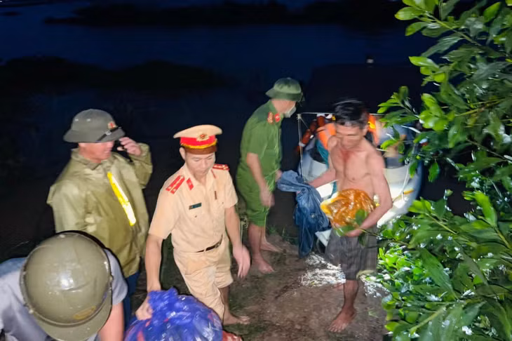 Lực lượng chức năng dùng ca nô giải cứu nhóm công nhân (Ảnh: Thúy Quỳnh).