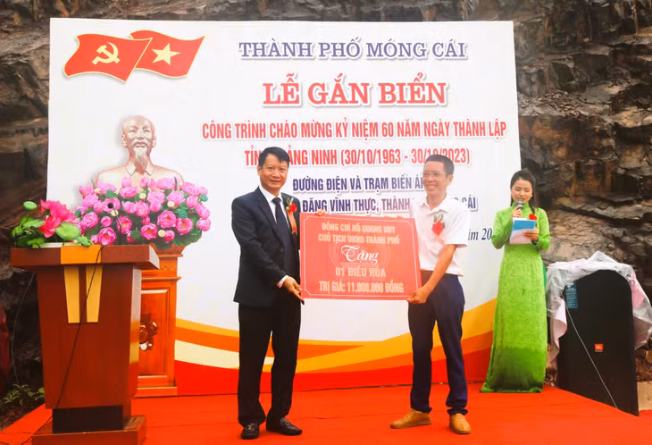 Ông Đồng Văn Cường, Trạm trưởng (áo trắng) hân hoan nhận món quà ý nghĩa từ Chủ tịch UBND TP Móng Cái Hồ Quang Huy.