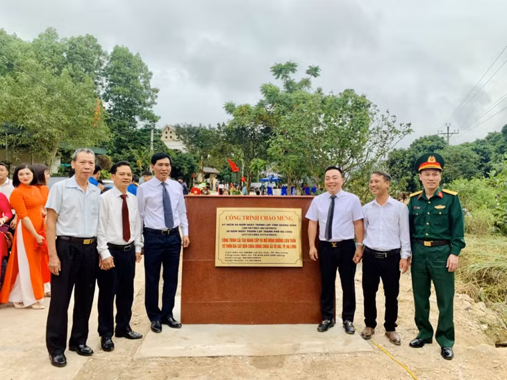 Các đại biểu thực hiện nghi thức gắn biển công trình cải tạo, nâng cấp và mở rộng đường liên thôn từ thôn Bãi Cát đến Chùa Đồng Chùa (xã Vũ Oai).
