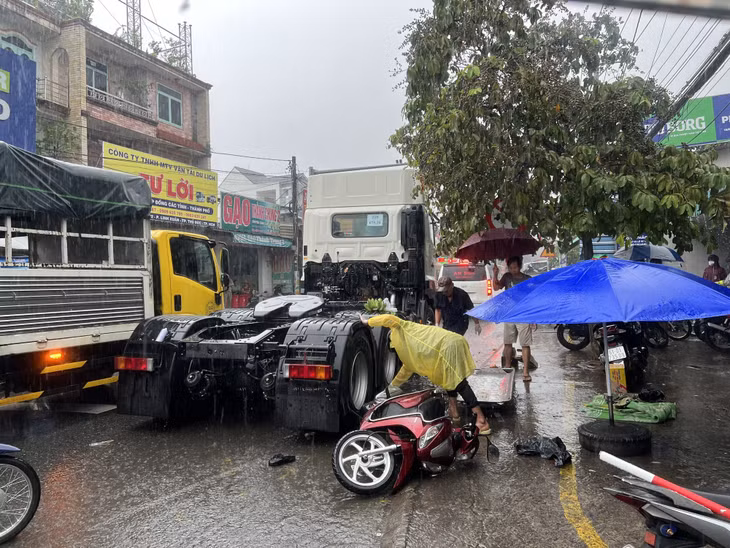 Người con gái lọt giữa gầm xe được người dân hỗ trợ kéo ra ngoài.