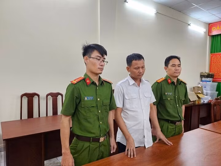 Lê Văn Ngọc (giữa) tại cơ quan công an.