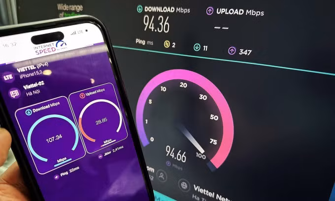 Một người đo tốc độ Internet trên PC và điện thoại di động ở Hà Nội. Ảnh: Lưu Quý