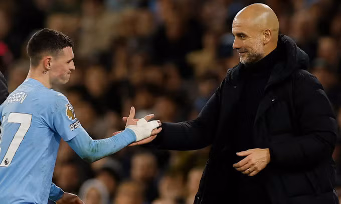 HLV Pep Guardiola mỉm cười với Foden khi rút anh rời sân sau cú hat-trick. Ảnh: Reuters