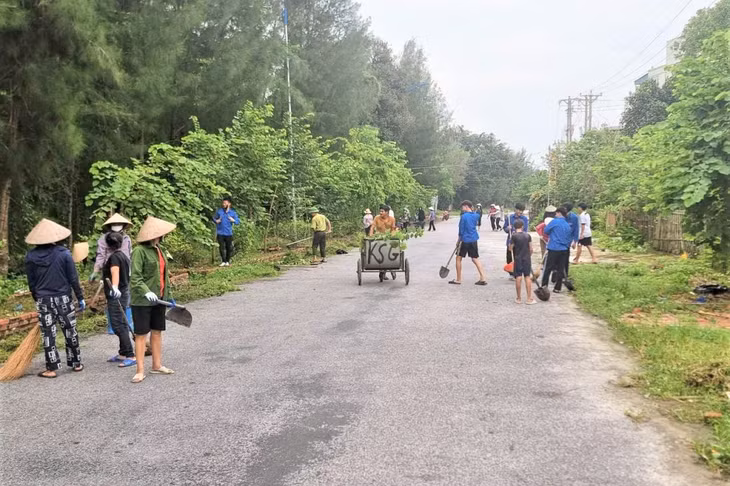 Cán bộ và nhân dân xã Minh Châu dọn vệ sinh khu vực đường trục chính. Ảnh: Đỗ Hiền (CTV)