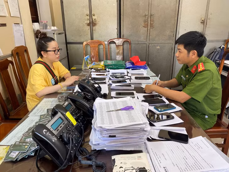 Cơ quan Công an lấy lời khai Lại Thị Ngọc Trang, đối tượng cầm đầu đường dây giả danh nhân viên ngân hàng gọi điện lừa đảo.
