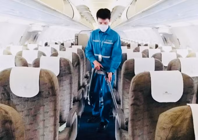 Anh Nguyễn Mạnh Đông làm công tác vệ sinh máy bay. Ảnh: VNA