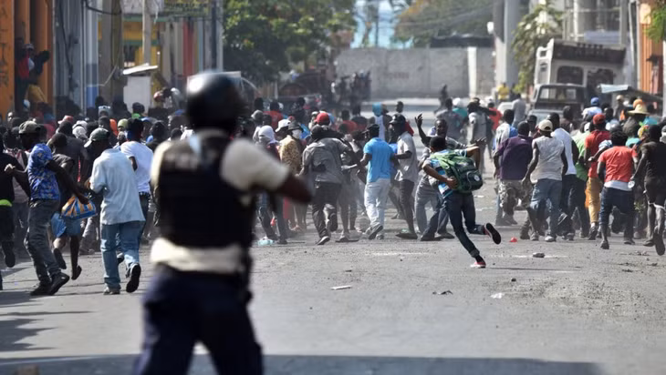 Người biểu tình bỏ chạy sau khi cảnh sát Haiti nổ súng trong cuộc đụng độ ở thủ đô Port-au-Princ. Ảnh tư liệu: AFP