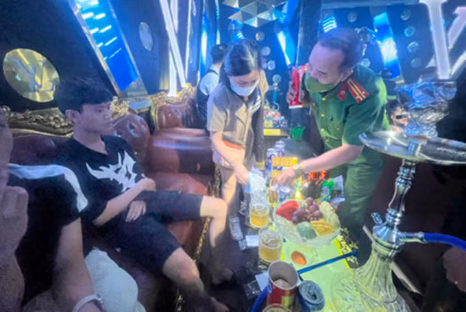 Cảnh sát kiểm tra nghi can tàng trữ ma tuý tại khu bàn VIP. Ảnh: Thái Hà