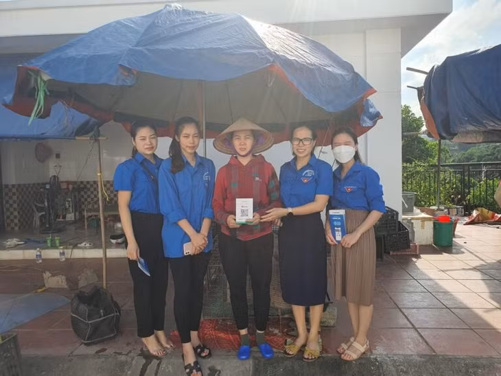 Đoàn thanh niên Thị trấn Ba Chẽ hướng dẫn các tiểu thương tại chợ Ba Chẽ áp dụng thanh toán không dùng tiền mặt.