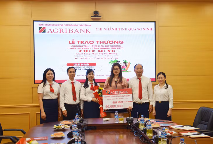 Lãnh đạo Agribank Quảng Ninh trao sổ tiết kiệm 50 triệu đồng cho khách hàng trúng thưởng giải Nhất.