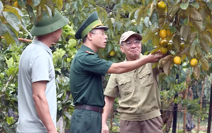 Thiếu tá Nguyễn Duy Tuấn cán bộ biên phòng tăng cường làm Phó Bí thư Đảng ủy xã Đồng Tiến (huyện Cô Tô) trao đổi với người dân về phát triển kinh tế.