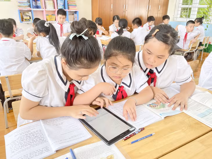 Học sinh lớp 5A, Trường Tiểu học Quyết Thắng (phường Mạo Khê) sử dụng máy tính bảng trong thảo luận bài học.