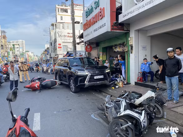 Xe 7 chỗ lùa nhiều xe máy gần Ngã tư Phú Nhuận, 3 người bị thương - Ảnh 1.