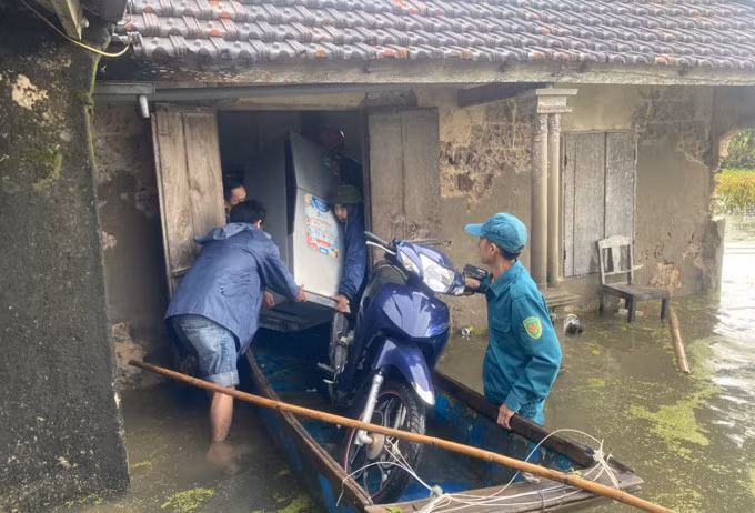 Các lực lượng hỗ trợ người dân thị xã Hoàng Mai di tản vật dụng khi nước tràn vào nhà. Ảnh: Hải Bình