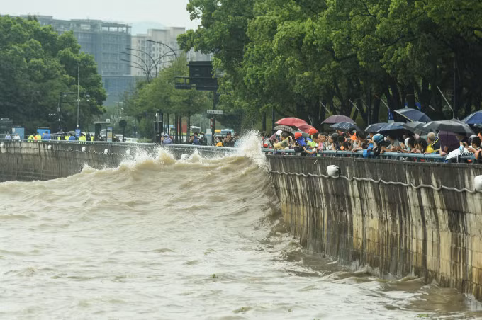 Người dân nhìn sóng đánh vào bờ biển Hàng Châu ngày 14/9, khi bão Muifa đổ bộ. Ảnh: AFP