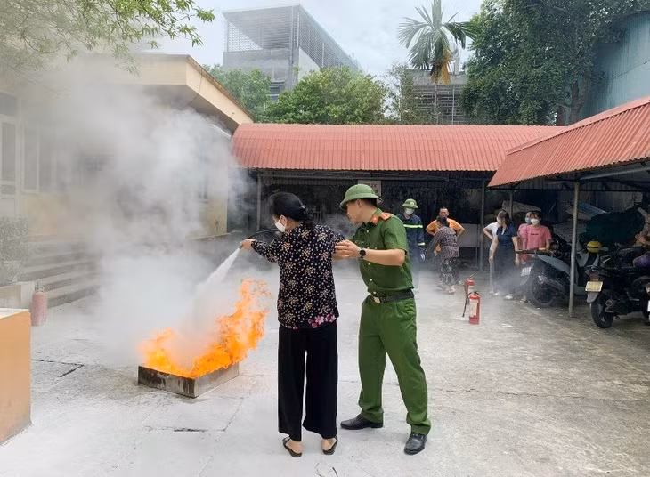 Thành viên "Tổ liên gia an toàn PCCC" tại khu phố Trần Bình Trọng (thị trấn Quảng Hà, huyện Hải Hà) thực hành cách sử dụng bình chữa cháy.
