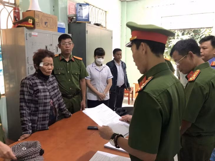 Công an đọc lệnh bắt giữ bị can Thông Thị Định (áo sọc).