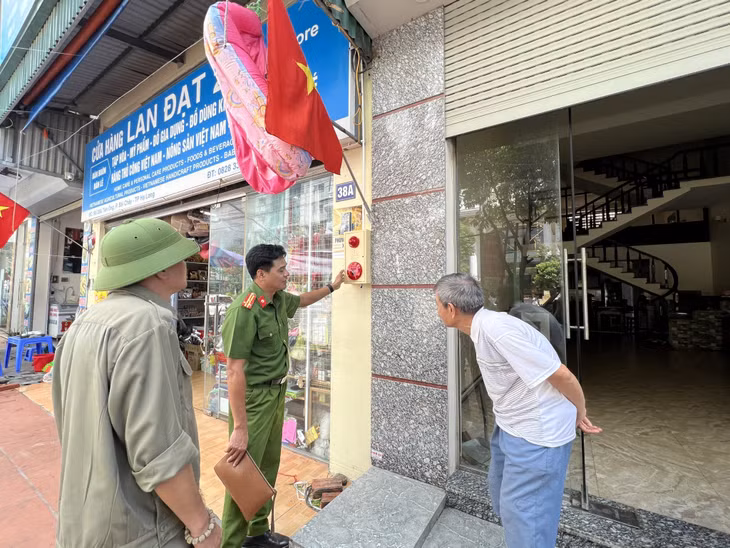 Công an TP Hạ Long hướng dẫn các hộ dân cách sử dụng chuông báo cháy.