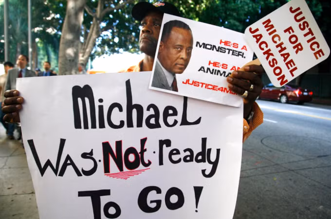 Fan cầm banner phản đối bác sĩ Murray sau khi Michael Jackson qua đời. Ảnh: AP