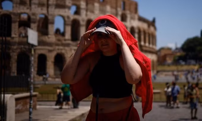 Người phụ nữ dùng áo để che nắng ở Rome, Italy, hôm 11/7. Ảnh: Reuters