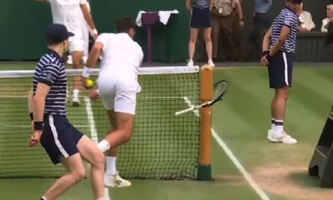 Djokovic đập vợt vào cột lưới sau khi thua game giao bóng quyết định.