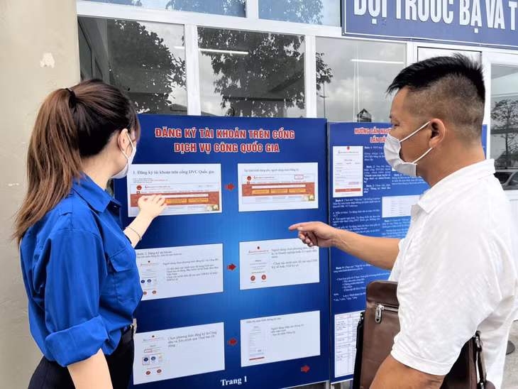 Đoàn viên thanh niên Chi cục Thuế TP Hạ Long hướng dẫn người dân đăng ký tài khoản giao dịch điện tử với cơ quan Thuế và thanh toán trực tuyến trên cổng dịch vụ công quốc gia. Ảnh: Yến Vy
