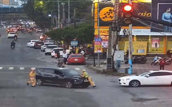 Hình ảnh thiếu tá CSGT Nghệ An bị tài xế Lê Thành Công hất lên nắp capo. Ảnh cắt từ clip.