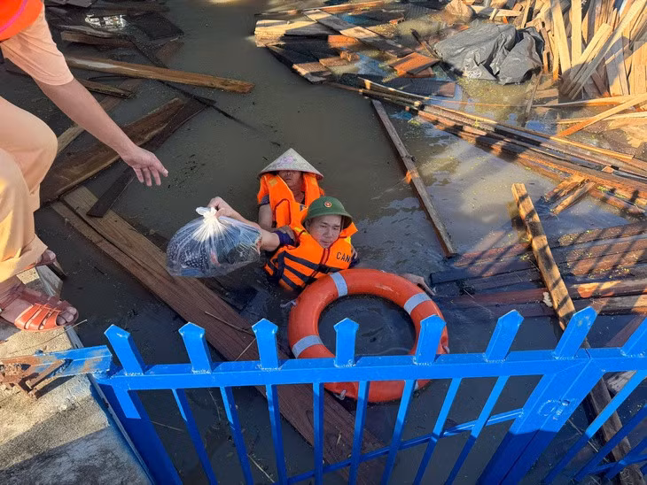 Thiếu tá Mai Thế Kiên và các cán bộ, chiến sĩ Công an tỉnh Bắc Ninh hỗ trợ người dân trong bão lũ - Ảnh: Công an tỉnh Bắc Ninh