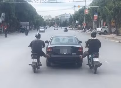 2 thanh niên ở Bắc Ninh dùng xe máy đẩy xe ô tô. Ảnh: Phòng CSGT Công an Bắc Ninh