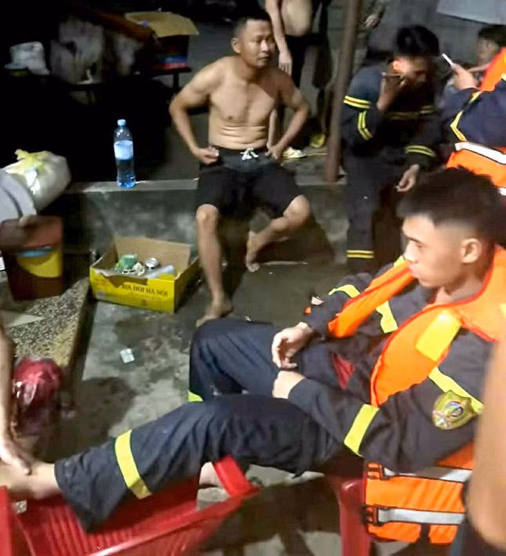 Những người trên chiếc xuồng bị lật được cứu kịp thời đưa vào nhà dân - Ảnh cắt từ clip