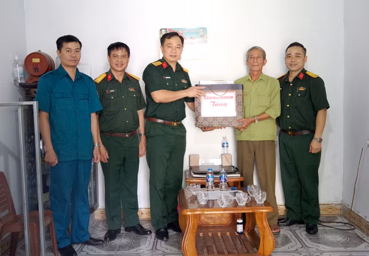 Đại tá Hoàng Văn Thuyết, Tỉnh ủy viên, Phó Bí thư Thường trực Đảng ủy, Chính ủy Bộ CHQS tỉnh tặng quà cho CCB Nguyễn Trọng Đỉnh ở khu 10, phường Bãi Cháy.
