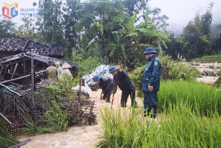 Lực lượng chức năng xã Hoành Mô giúp người dân khơi thông dòng chảy, tránh ngập úng vào nhà và hoa màu.