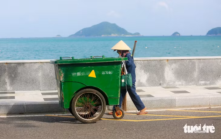 Công nhân môi trường quét dọn lá rụng trên tuyến đường ven biển, giữ vỉa hè luôn sạch cho người dân và du khách