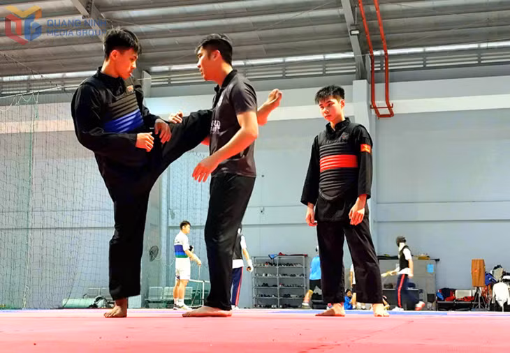 HLV Nguyễn Thái Linh chỉ dẫn kỹ thuật cho 2 VĐV Nguyễn Quang Thành, Lê Thành Trung.