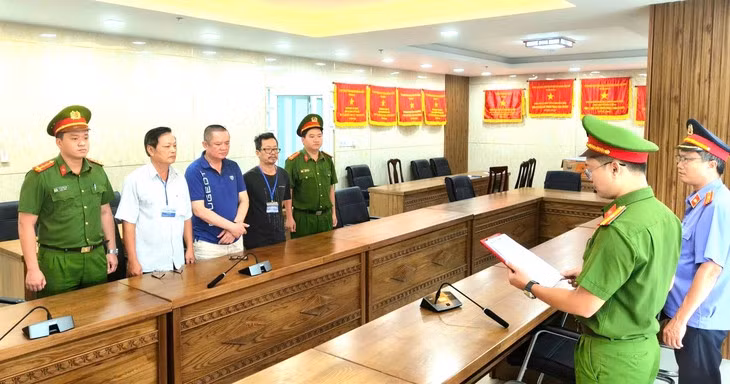 Cơ quan điều tra tống đạt các quyết định - Ảnh: H.B.