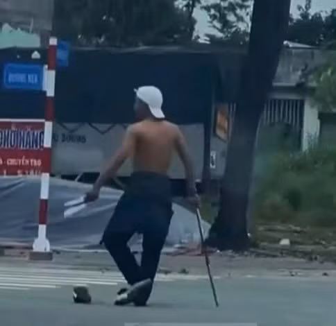Đối tượng có biểu hiện không bình thường, cầm 2 con dao và gậy chạy trên đường. Ảnh cắt từ clip bạn đọc cung cấp