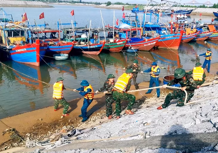 Lực lượng biên phòng Hà Tĩnh hỗ trợ ngư dân chằng chống tàu thuyền để phòng tránh bão - Ảnh: LÊ MINH