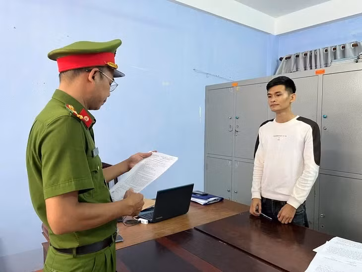 Đại diện cơ quan điều tra tống đạt quyết định khởi tố bị can, lệnh cấm đi khỏi nơi cư trú, tạm hoãn xuất cảnh đối với thanh niên xăm trổ Trần Triệu Quí, người đã đánh phụ nữ mang thai bán hàng tạp hóa - Ảnh: KHANG VÕ