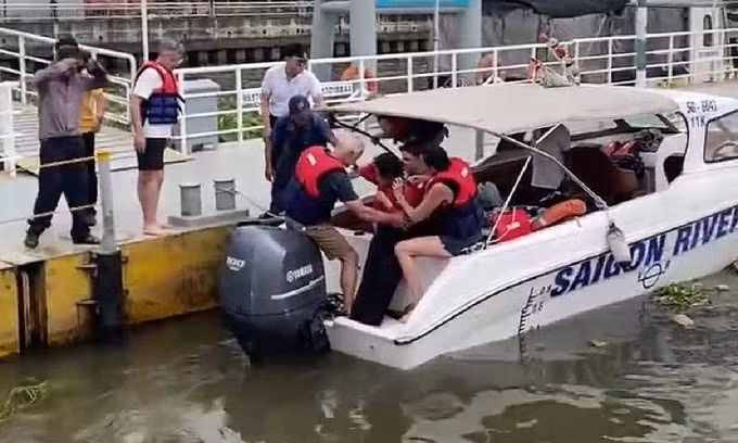 Người phụ nữ được đưa từ cano lên bờ. Ảnh: Ngọc Phú