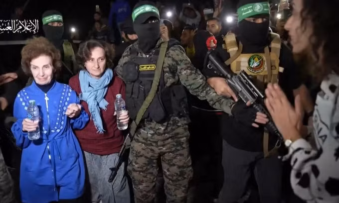 Các tay súng Hamas bàn giao con tin cho Hội chữ thập đỏ ở Dải Gaza hôm 29/11. Ảnh: AFP