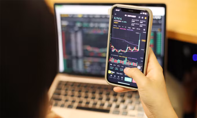 Một người theo dõi tiền điện tử qua ứng dụng smartphone. Ảnh: Khương Nha