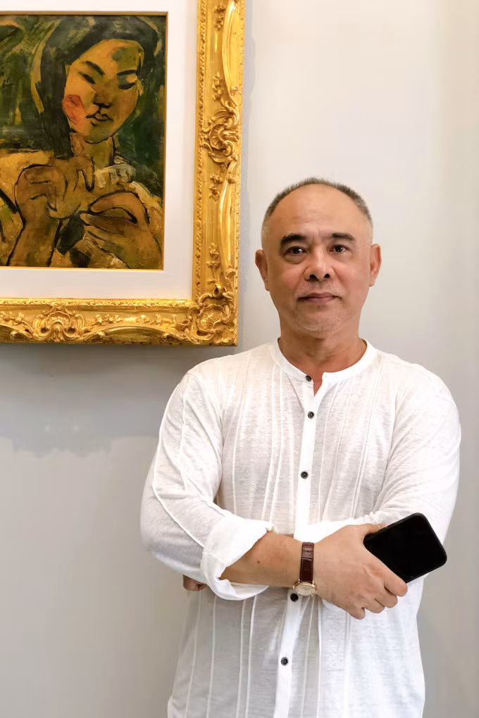 Nhà sưu tập Trần Hậu Tuấn bên một tác phẩm của Bùi Xuân Phái. Ảnh: Mai Nhật