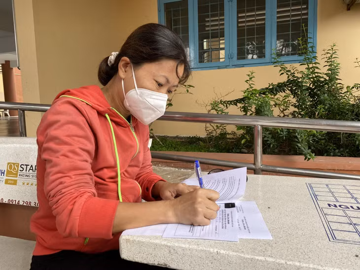 Một phụ huynh tại huyện Củ Chi, TP.HCM ký vào phiếu đồng thuận tiêm chủng cho học sinh.