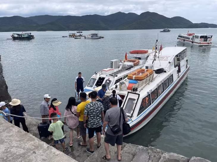 Khách du lịch lên tàu tham quan đảo Minh Châu (huyện Vân Đồn).