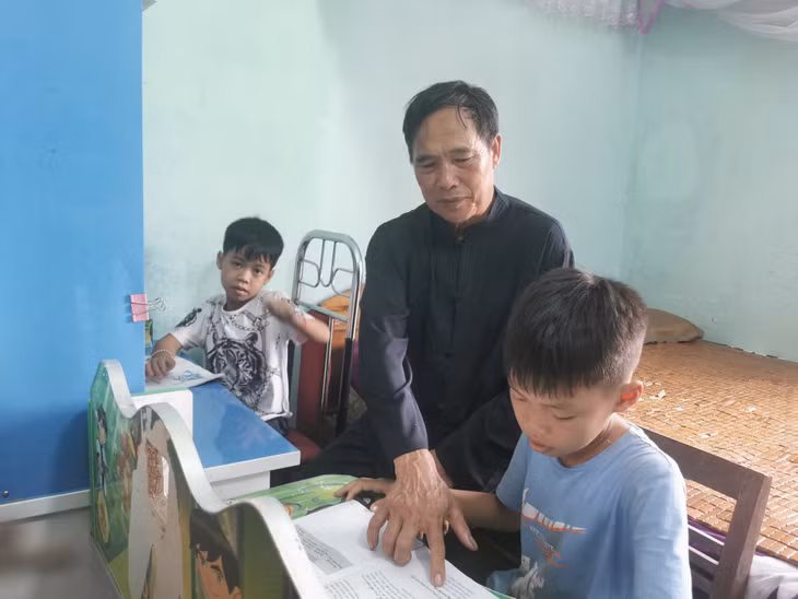 Ông Lầu Tằng Sáng, dân tộc Sán Dìu (bản Thanh Lâm, xã Quảng Lâm, huyện Đầm Hà) kèm các cháu học tập.