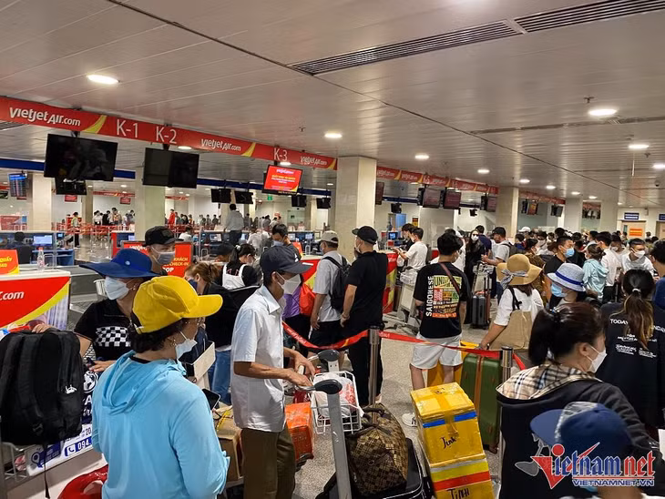 Hành khách đổ về sân bay Tân Sơn Nhất, tập trung trước quầy vé của hãng hàng không Vietjet để chờ làm thủ tục