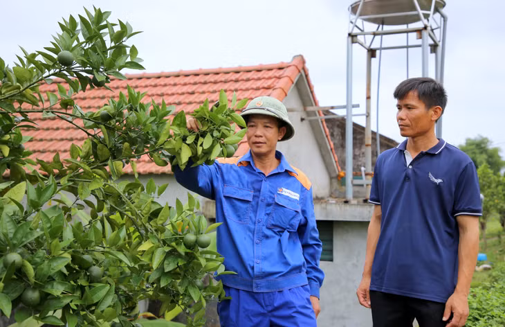 Cán bộ thôn Đông Dương, xã Đông Ngũ, huyện Tiên Yên (bên phải) thăm mô hình kinh tế của người dân trên địa bàn.