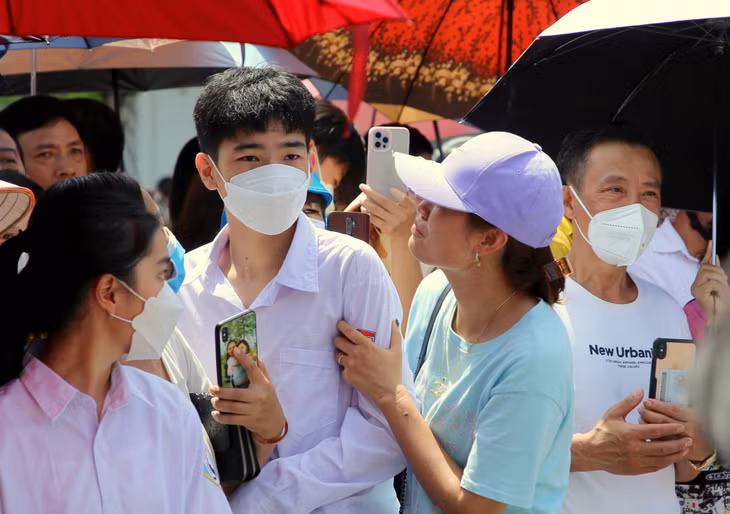 Các bậc phụ huynh hỏi han kết quả làm bài của con em ngay khi kết thúc buổi thi.